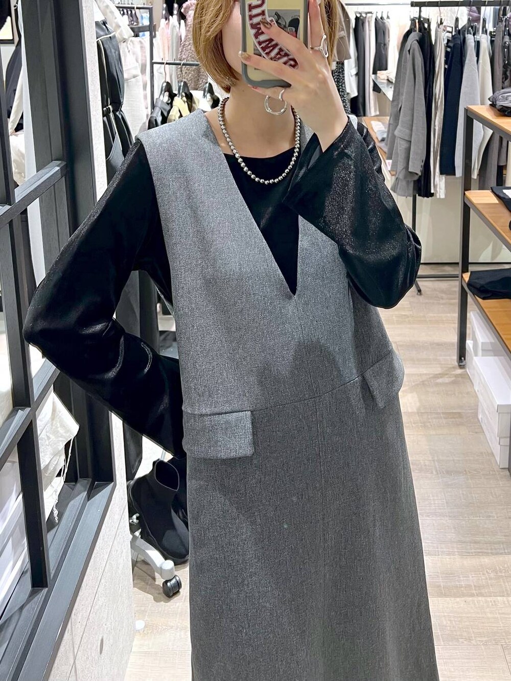 ブラック系のブルゾン、ブラック系のブーツ、グレー系のジャンパースカートを着用したレディースの秋コーディネートの8枚目の写真