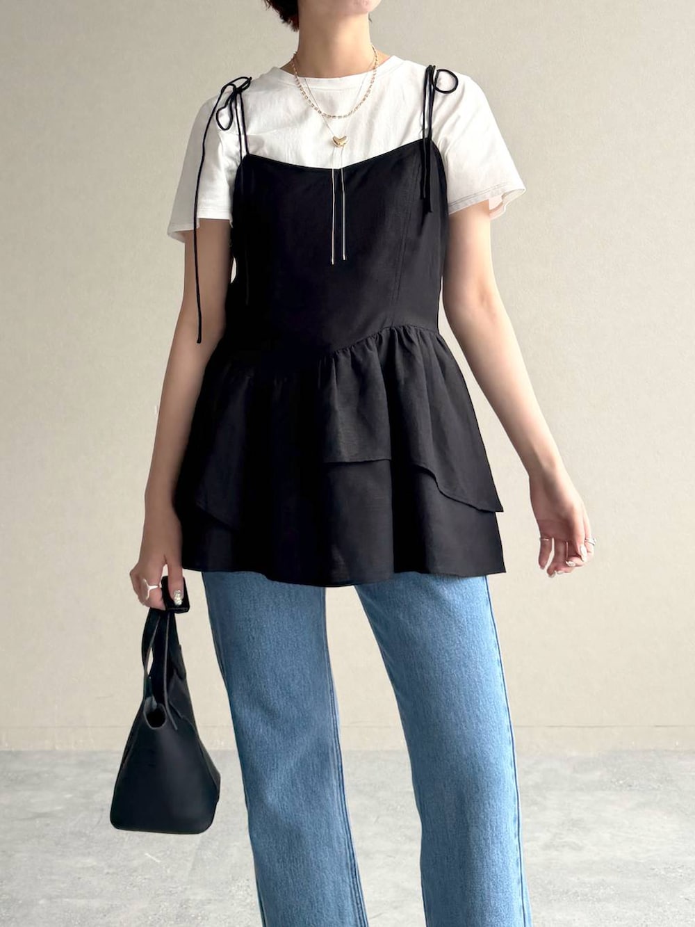 ブルー系のデニムパンツ、ブラック系のサンダル、ブラック系のシャツ/ブラウスを着用したレディースの夏コーディネートの4枚目の写真