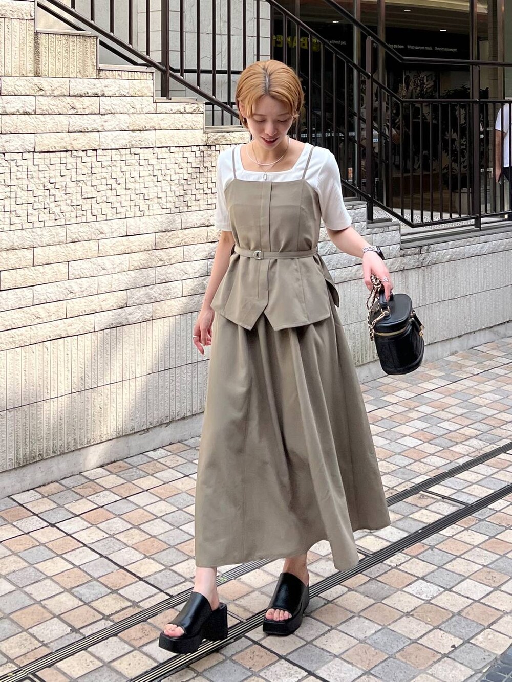 ブラック系のサンダル、ホワイト系のTシャツ/カットソー、ブラック系のショルダーバッグを着用したレディースの夏コーディネートの2枚目の写真