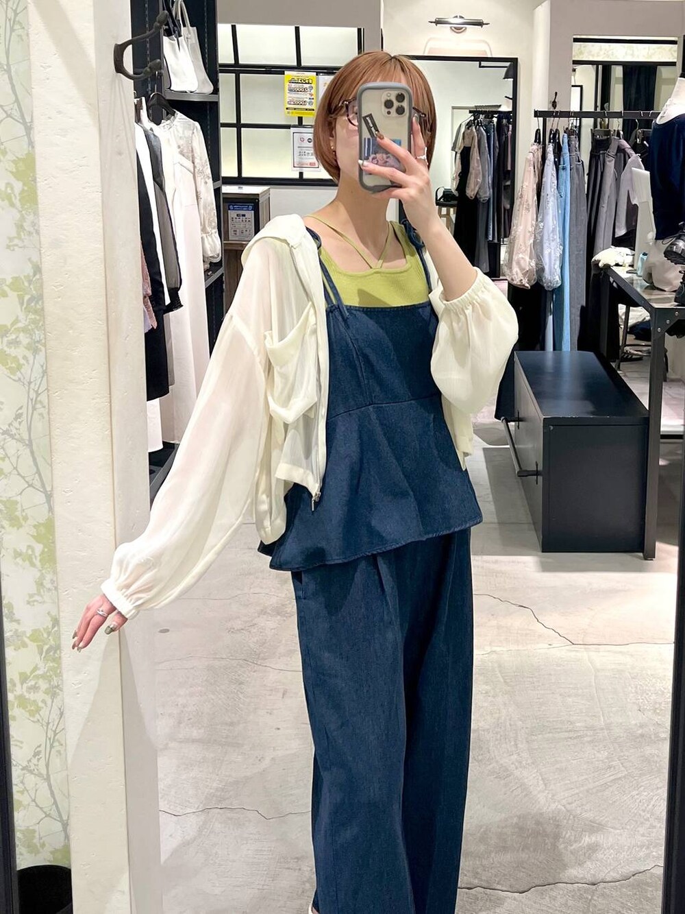 ホワイト系のパーカー、ブルー系のサロペット/オーバーオール、グリーン系のタンクトップを着用したレディースの春コーディネートの2枚目の写真