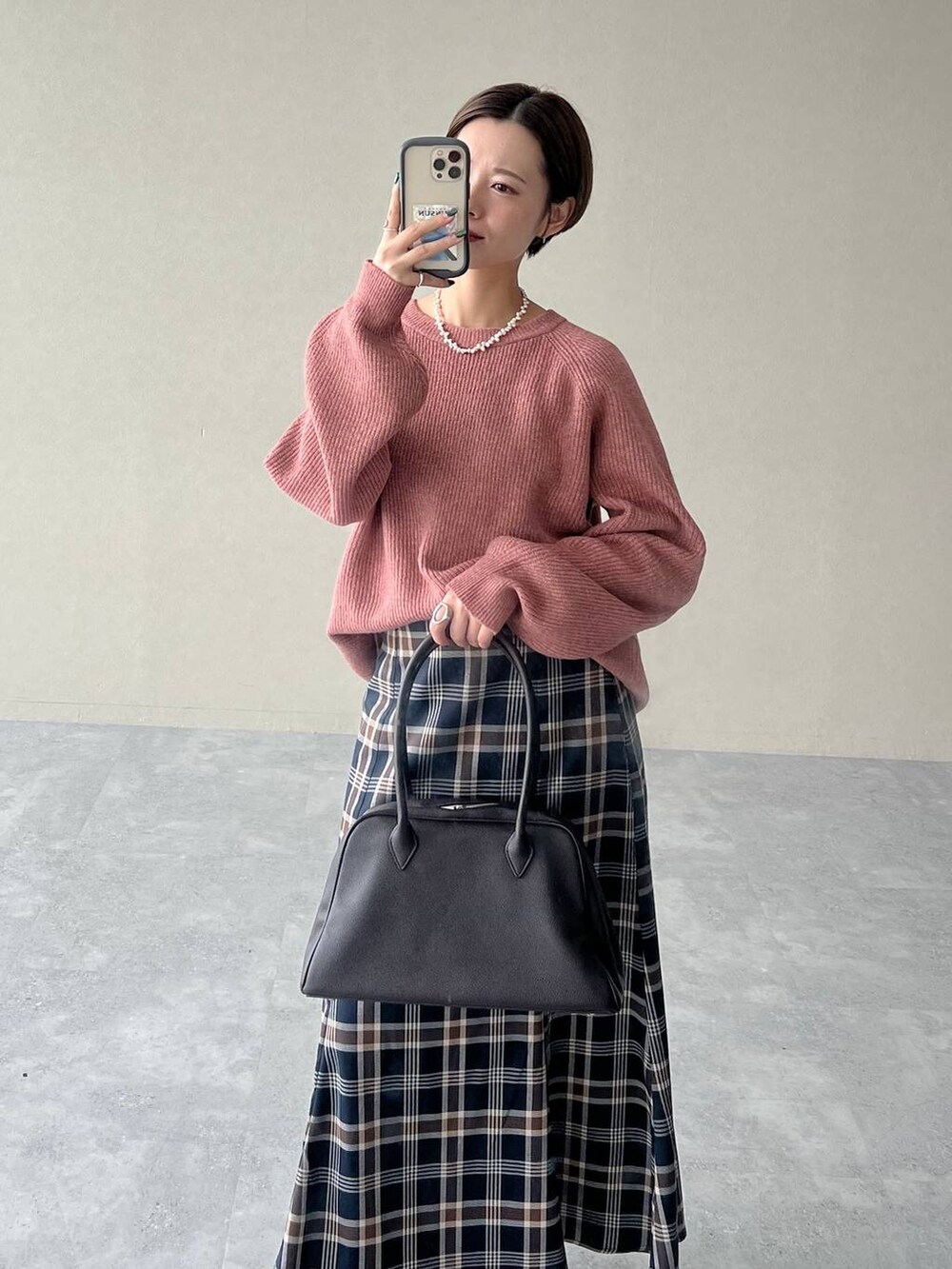 ピンク系のニット/セーター、ブラウン系のブーツ、ブラウン系のトートバッグを着用したレディースの秋コーディネートの4枚目の写真