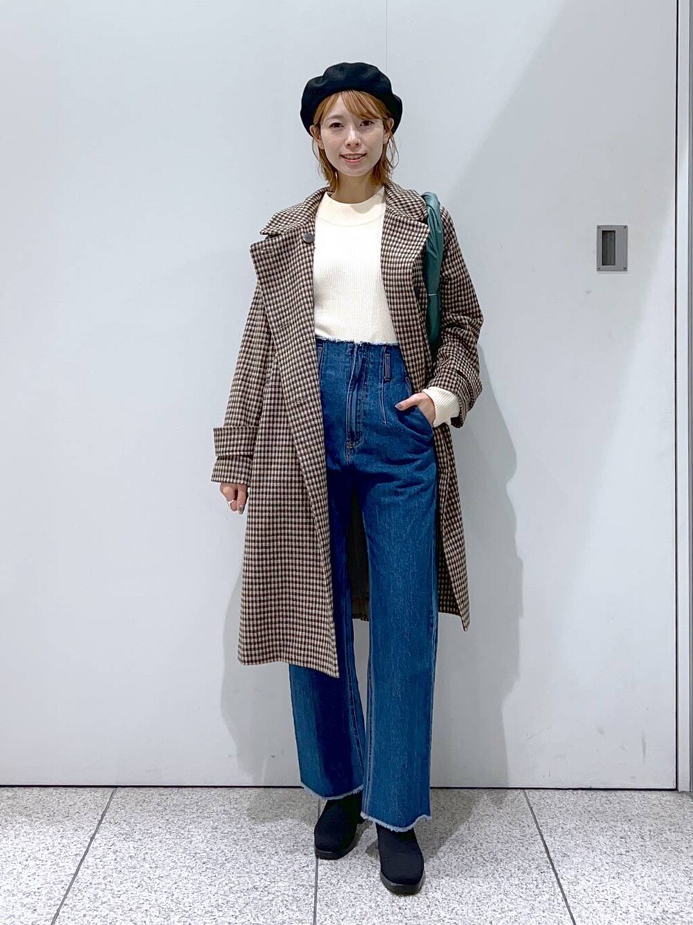 ブルー系のデニムパンツ、ブラック系のブーツ、ホワイト系のニット/セーターを着用したレディースの秋コーディネートの4枚目の写真