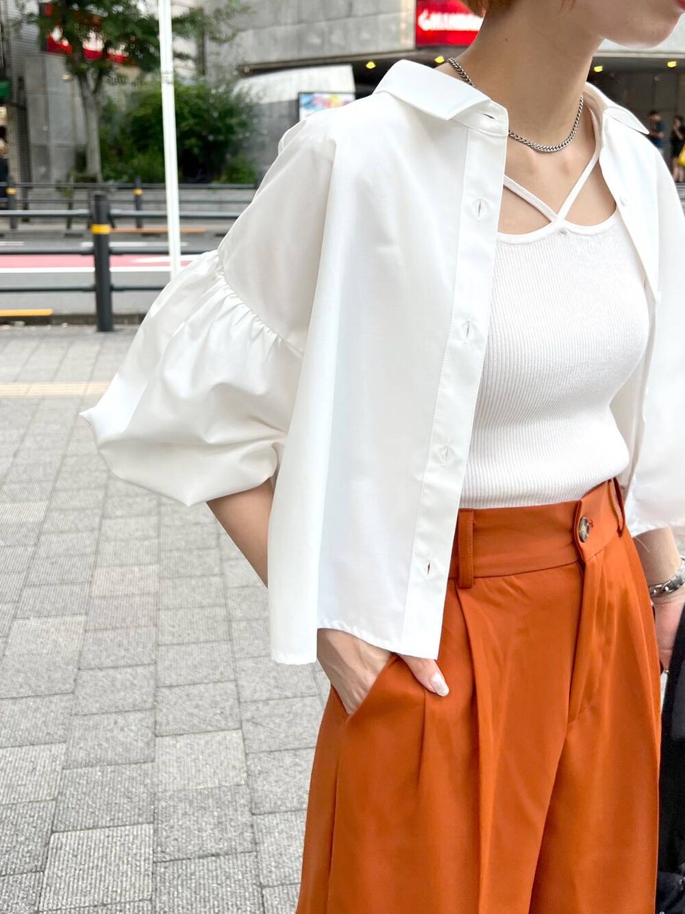 ブラック系のショルダーバッグ、ホワイト系のシャツ/ブラウス、オレンジ系のスラックスを着用したレディースの秋コーディネートの4枚目の写真