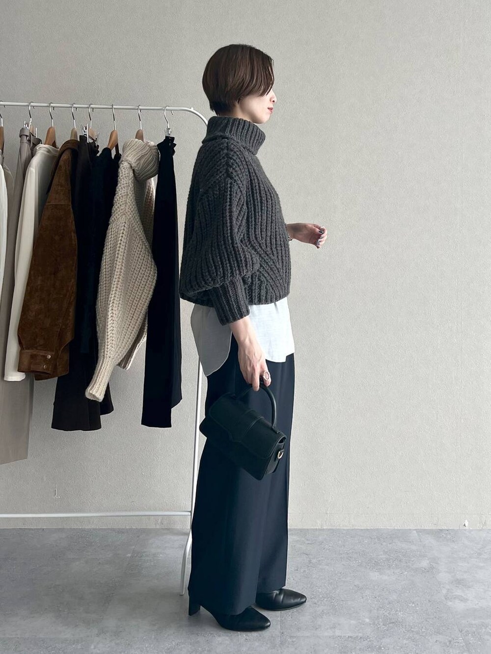 ブルー系のスラックス、ホワイト系のTシャツ/カットソー、ブラック系のブーツを着用したレディースの秋コーディネートの2枚目の写真