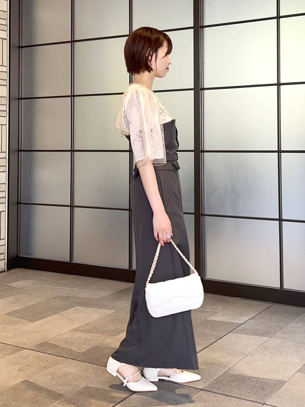 ホワイト系のシャツ/ブラウス、ホワイト系のショルダーバッグ、ホワイト系のパンプスを着用したレディースの夏コーディネートの2枚目の写真