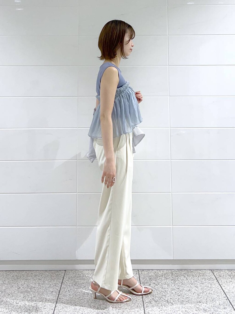 ブルー系のシャツ/ブラウス、ホワイト系のサンダル、ホワイト系のハンドバッグを着用したレディースの春コーディネートの5枚目の写真