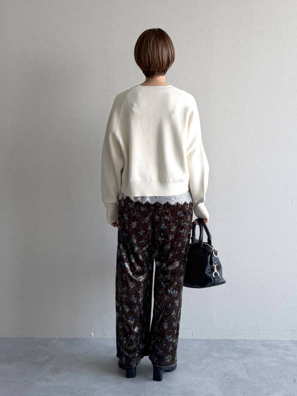 ブラック系のボストンバッグ、ブラック系のブーツ、ホワイト系のキャミソールを着用したレディースの冬コーディネートの7枚目の写真