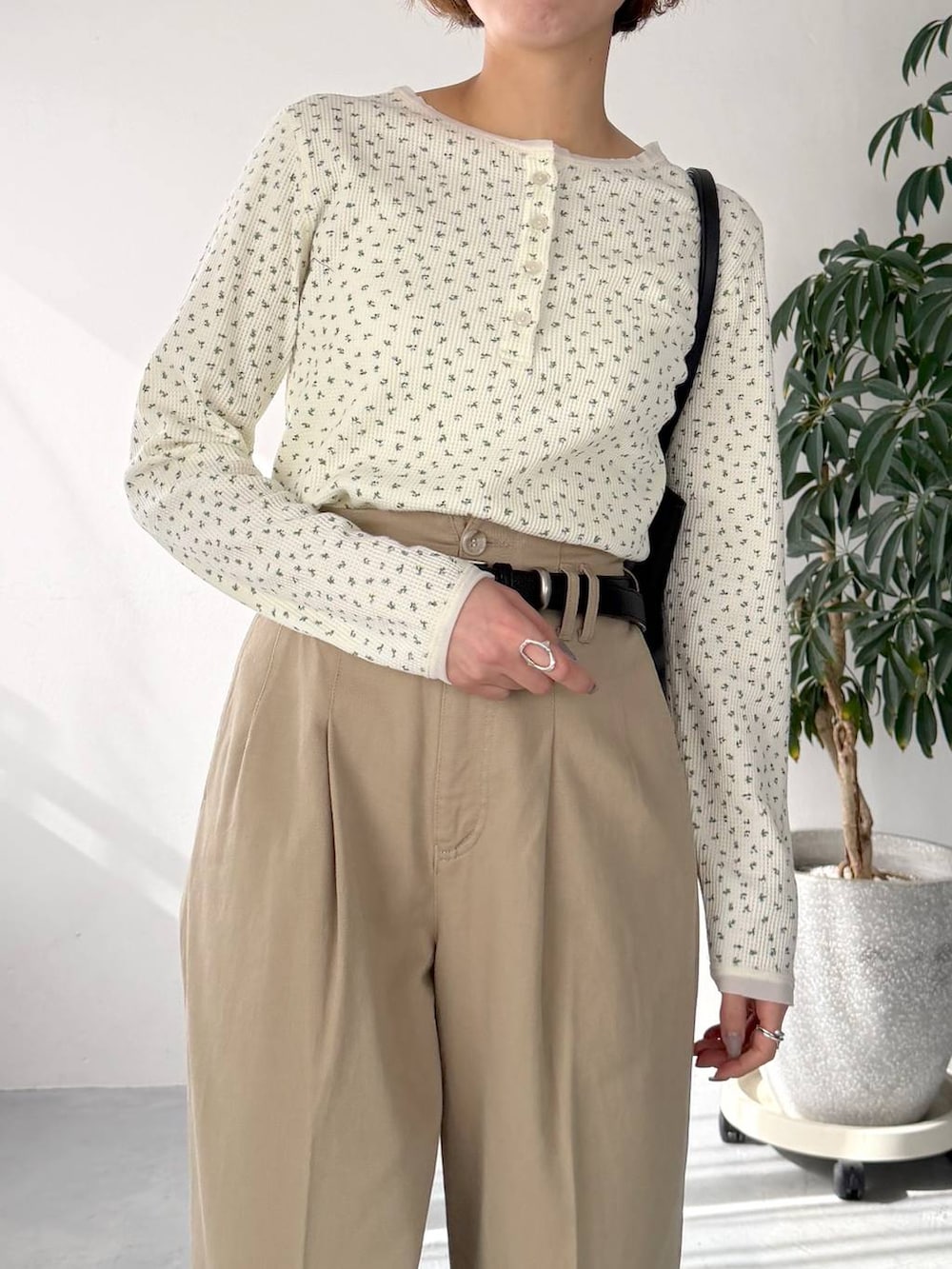 ホワイト系のTシャツ/カットソー、ベージュ系のチノパンツ、ブラック系のトートバッグを着用したレディースの春コーディネートの4枚目の写真