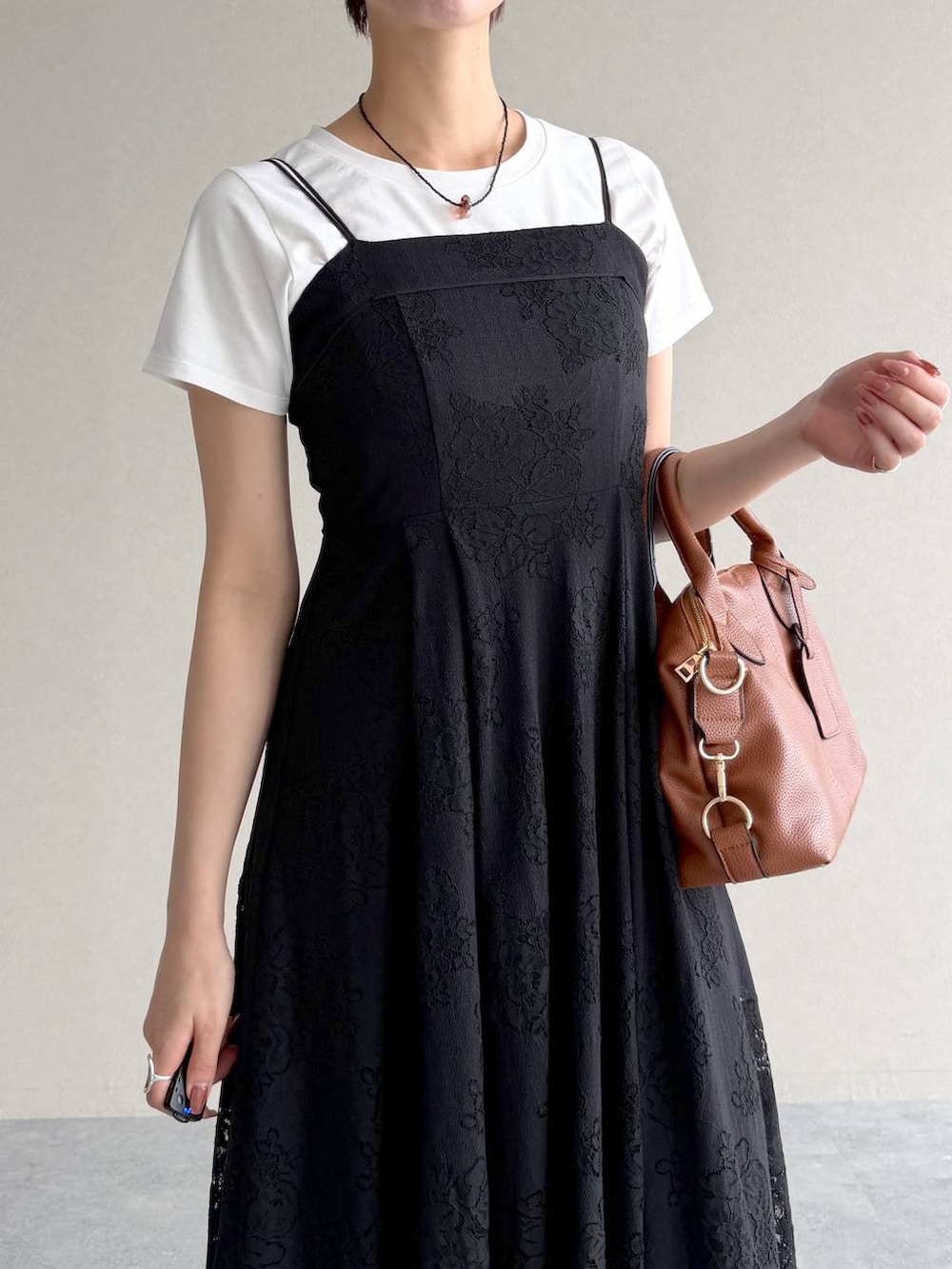 ホワイト系のTシャツ/カットソー、ブラック系のワンピース、ブラウン系のボストンバッグを着用したレディースの夏コーディネートの4枚目の写真