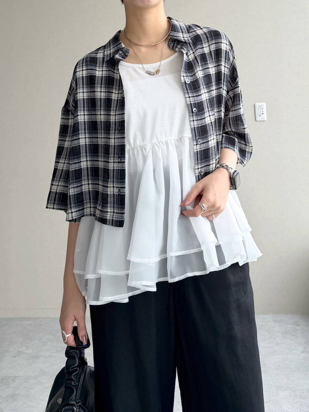 ブラック系のシャツ/ブラウス、ブルー系のニット/セーター、ブラック系のサンダルを着用したレディースの夏コーディネートの4枚目の写真
