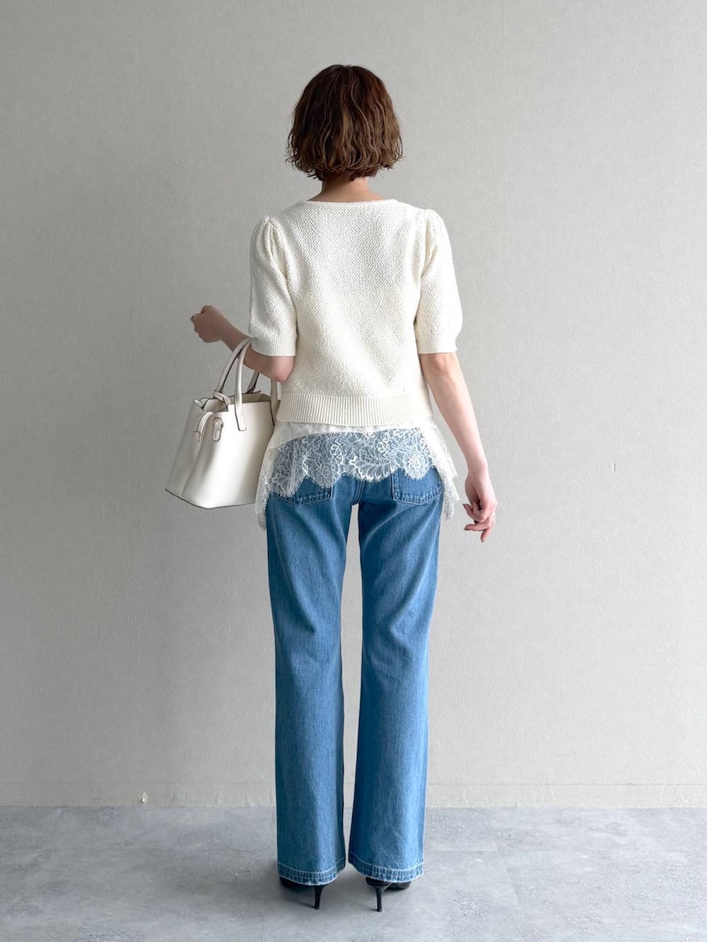 ホワイト系のカーディガン/ボレロ、ブルー系のデニムパンツ、ブラック系のサンダルを着用したレディースの春コーディネートの3枚目の写真