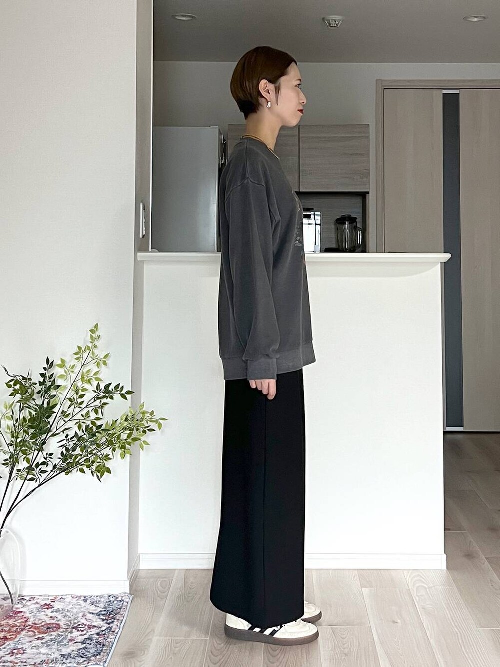 ブラウン系のボストンバッグ、ブラック系のスカート、ベージュ系のネックレスを着用したレディースの秋コーディネートの6枚目の写真