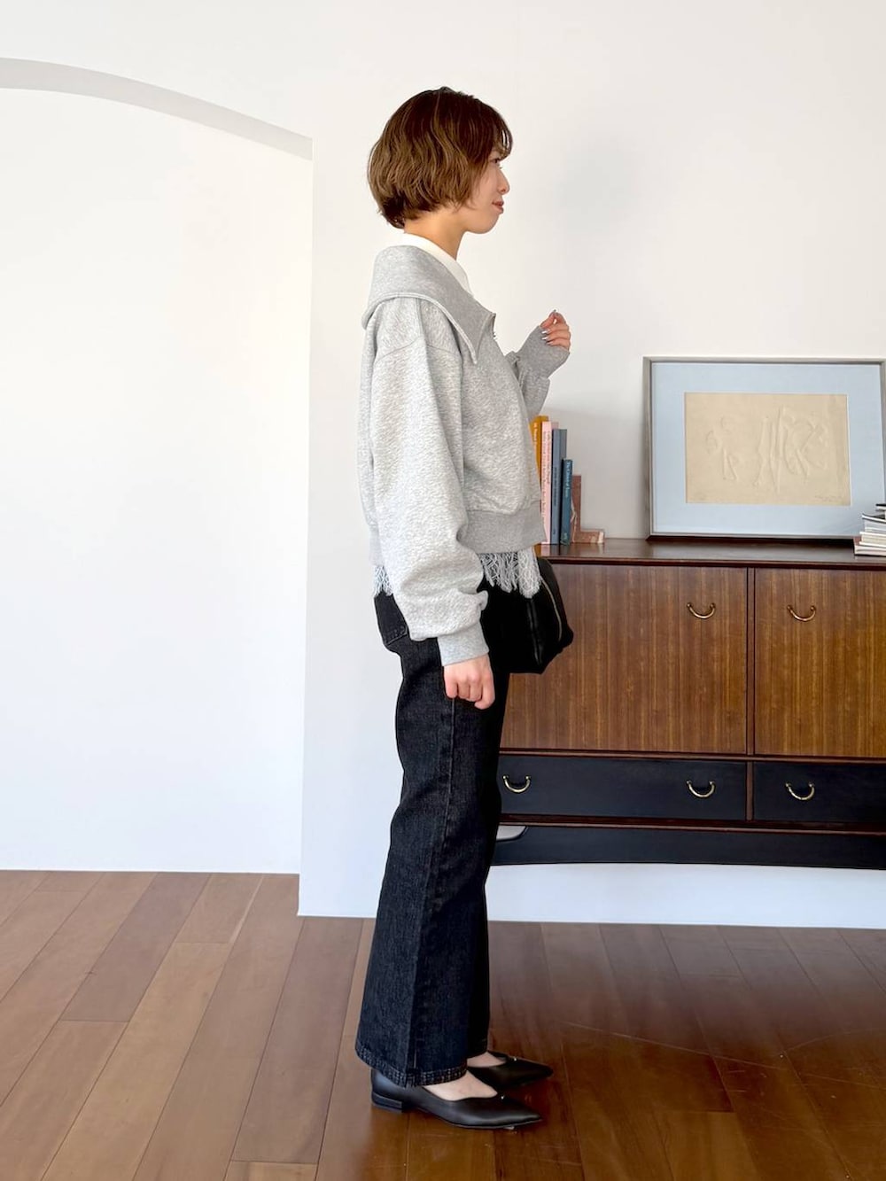 ブラック系のハンドバッグ、ブラック系のデニムパンツ、ブラック系のパンプスを着用したレディースの冬コーディネートの2枚目の写真