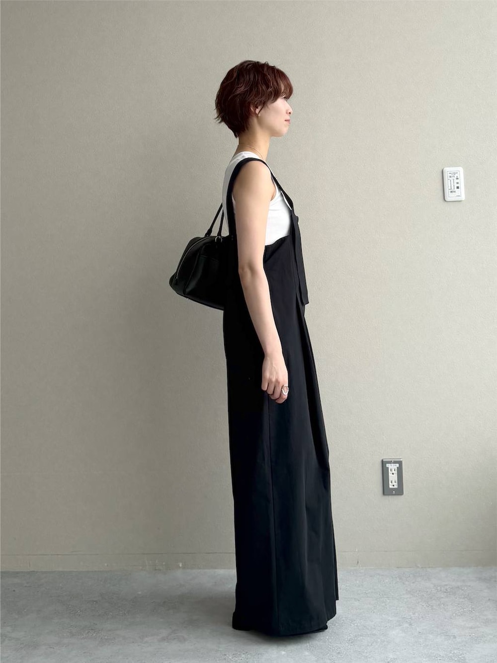 ブラック系のサンダル、ホワイト系のタンクトップ、ブラック系のハンドバッグを着用したレディースの夏コーディネートの2枚目の写真