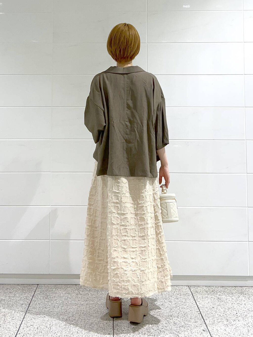 ベージュ系のサンダル、ホワイト系のショルダーバッグ、ベージュ系のワンピースを着用したレディースの夏コーディネートの3枚目の写真