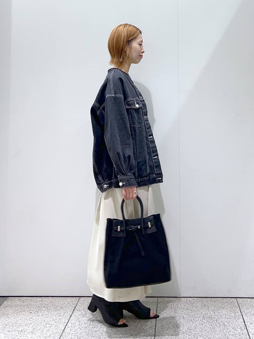 ホワイト系のワンピース、ブラック系のトートバッグ、ホワイト系のTシャツ/カットソーを着用したレディースの冬コーディネートの2枚目の写真