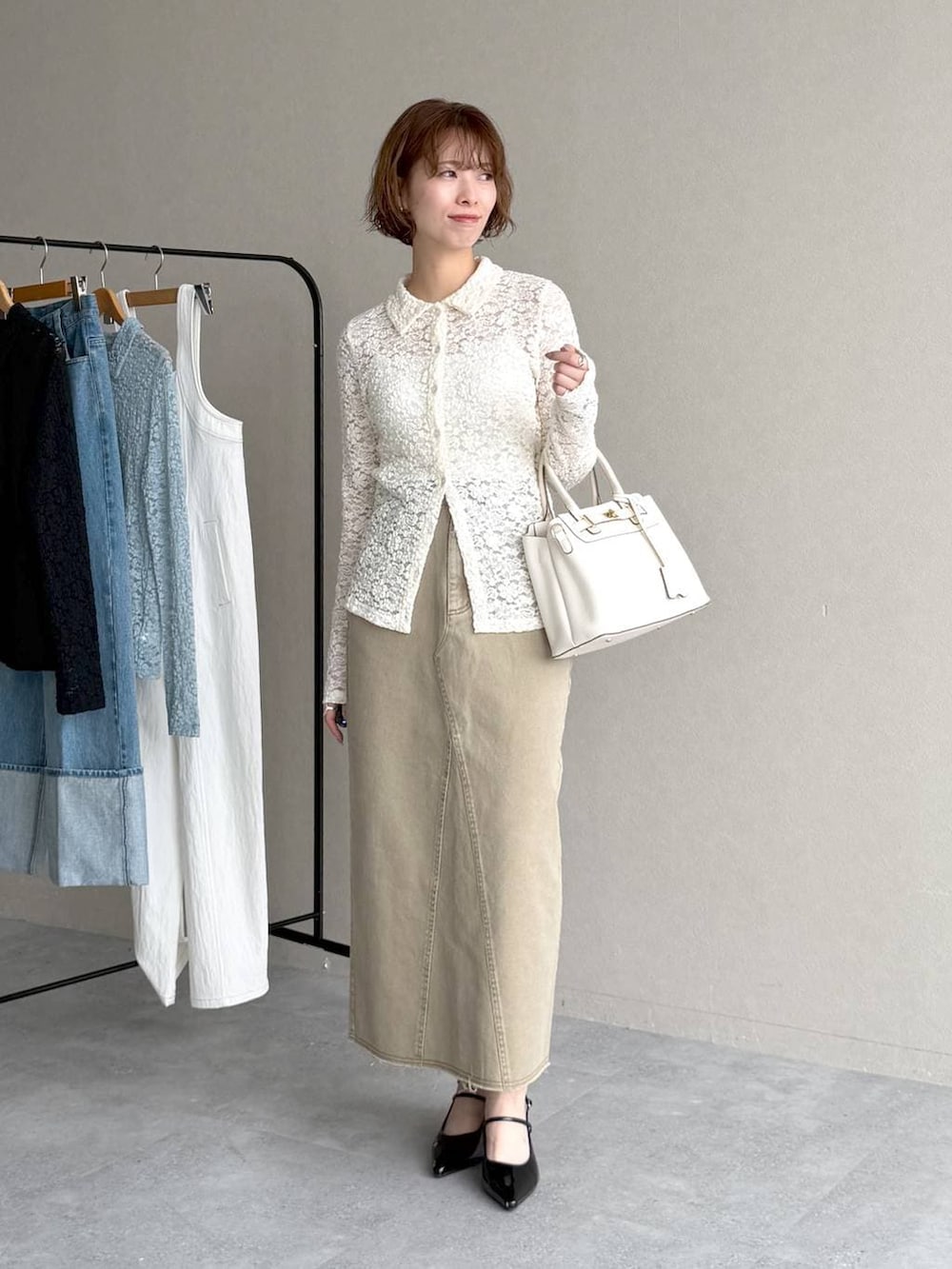 ブラック系のサンダル、ブルー系のテーラードジャケット、ベージュ系のスカートを着用したレディースの春コーディネートの4枚目の写真