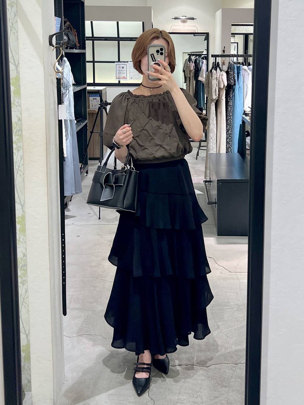 ブラック系のショルダーバッグ、ブラウン系のシャツ/ブラウス、ブラック系のスカートを着用したレディースの夏コーディネートの4枚目の写真