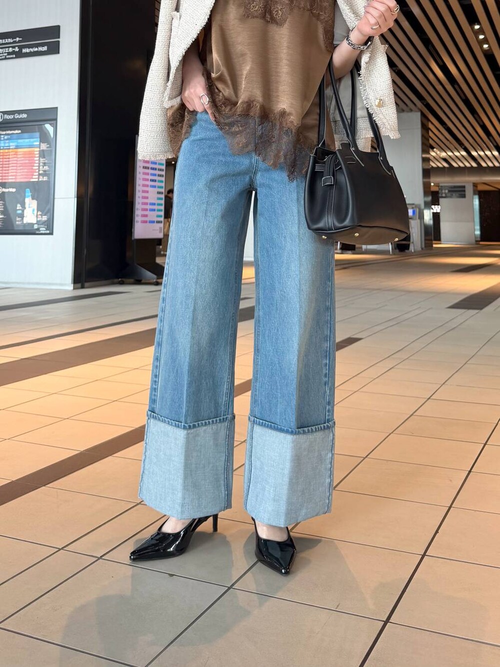 ブラック系のサンダル、ブラウン系のキャミソール、ホワイト系のノーカラージャケットを着用したレディースの春コーディネートの9枚目の写真