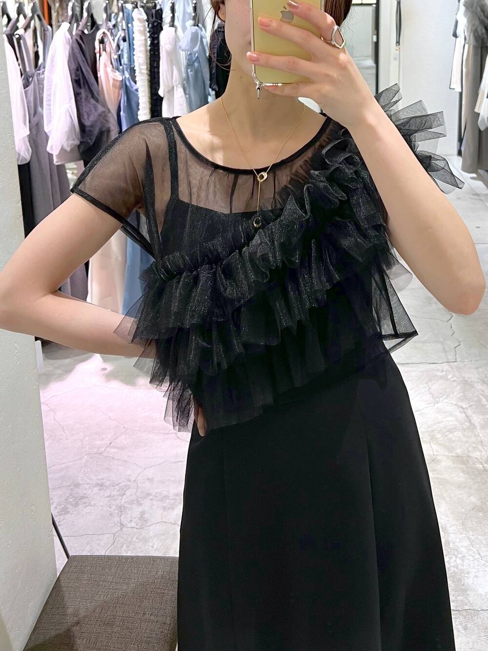 ブラック系のパンプス、ブラック系のドレス、ブラック系のショルダーバッグを着用したレディースの夏コーディネートの4枚目の写真