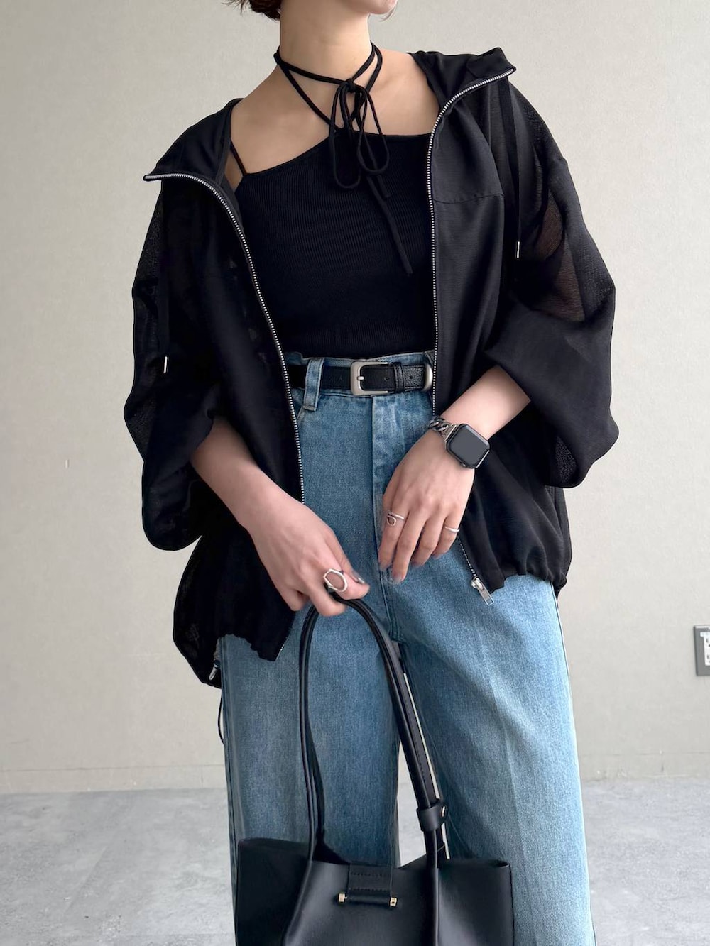 ブラック系のサンダル、ブルー系のデニムパンツ、ブラック系のキャミソールを着用したレディースの春コーディネートの4枚目の写真