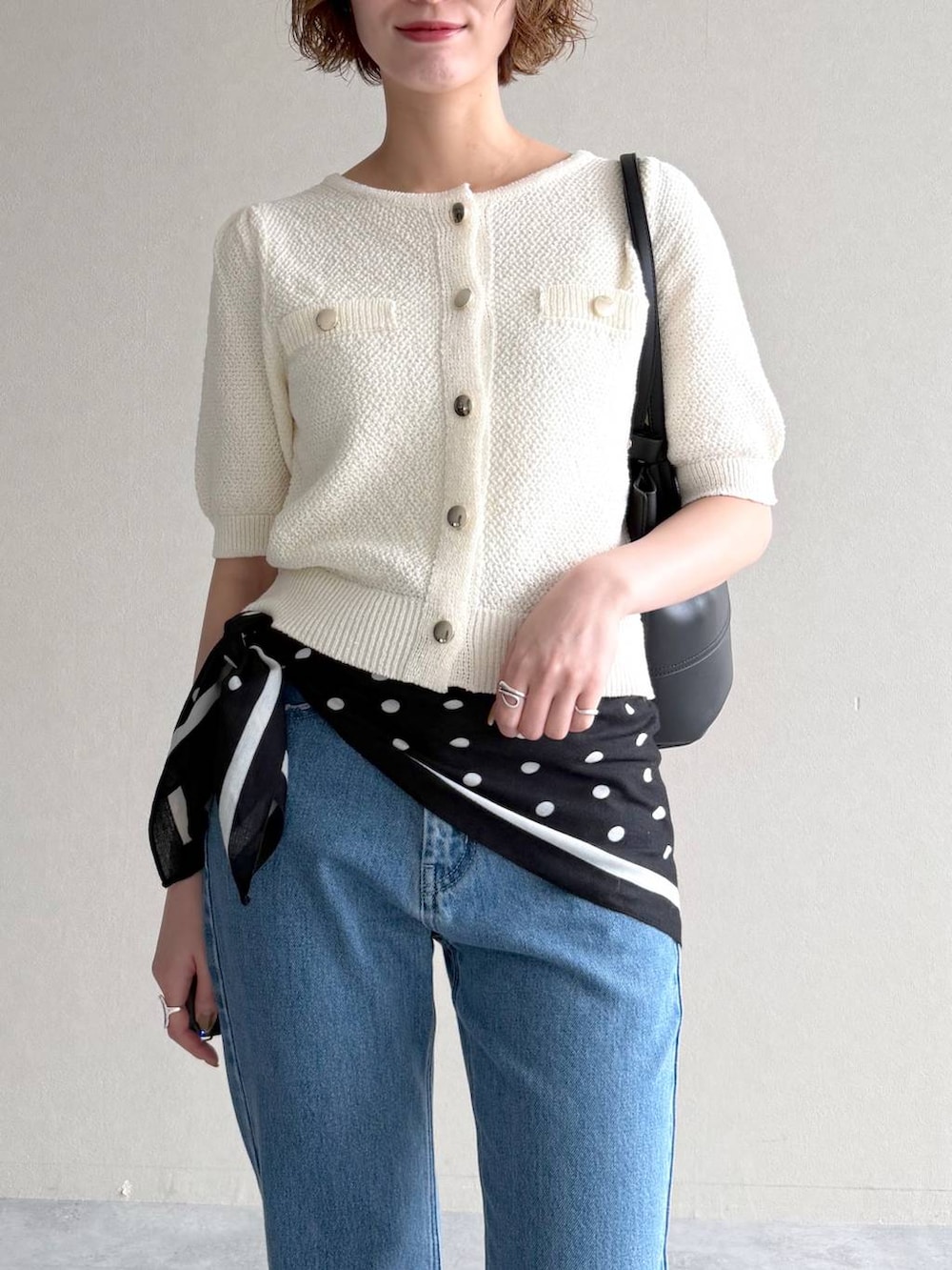 ホワイト系のカーディガン/ボレロ、ブルー系のデニムパンツ、ブラック系のサンダルを着用したレディースの春コーディネートの4枚目の写真