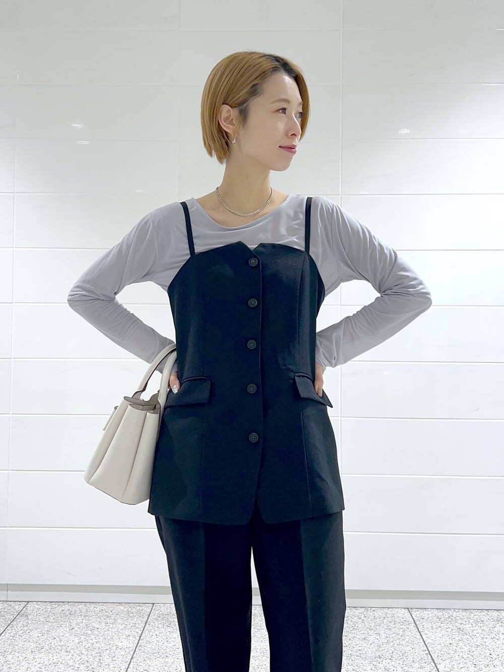 グレー系のTシャツ/カットソー、ブラック系のブーツ、ホワイト系のショルダーバッグを着用したレディースの冬コーディネートの7枚目の写真