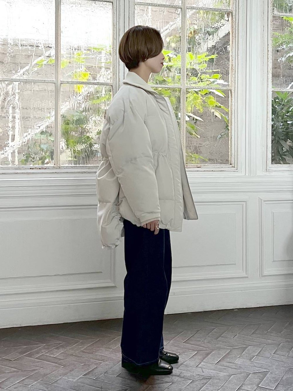 ブルー系のデニムパンツ、ブラック系のローファー、ホワイト系のニット/セーターを着用したレディースの冬コーディネートの2枚目の写真