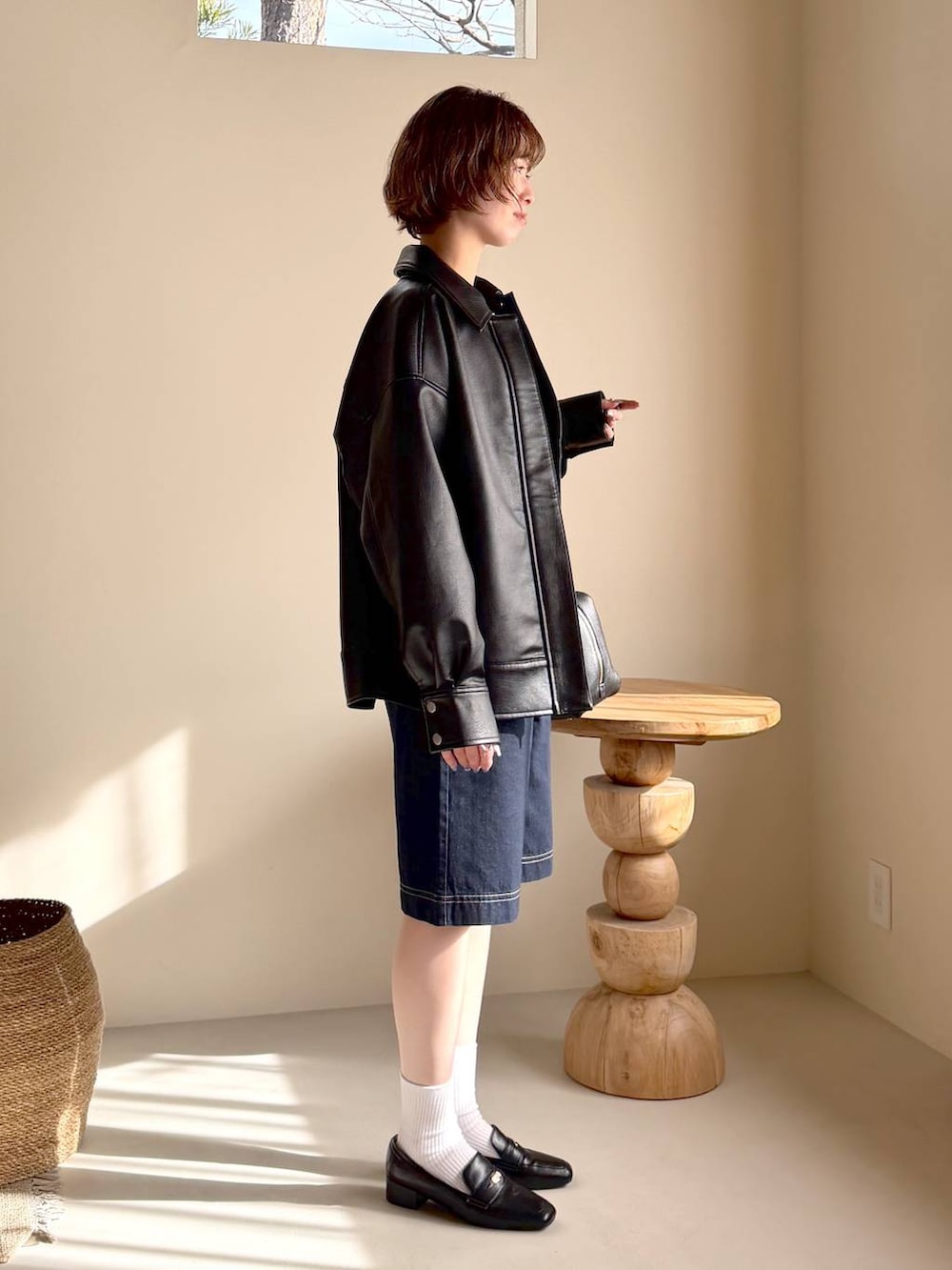 ブラック系のハンドバッグ、ブラック系のローファー、ブラック系のブルゾンを着用したレディースの冬コーディネートの2枚目の写真