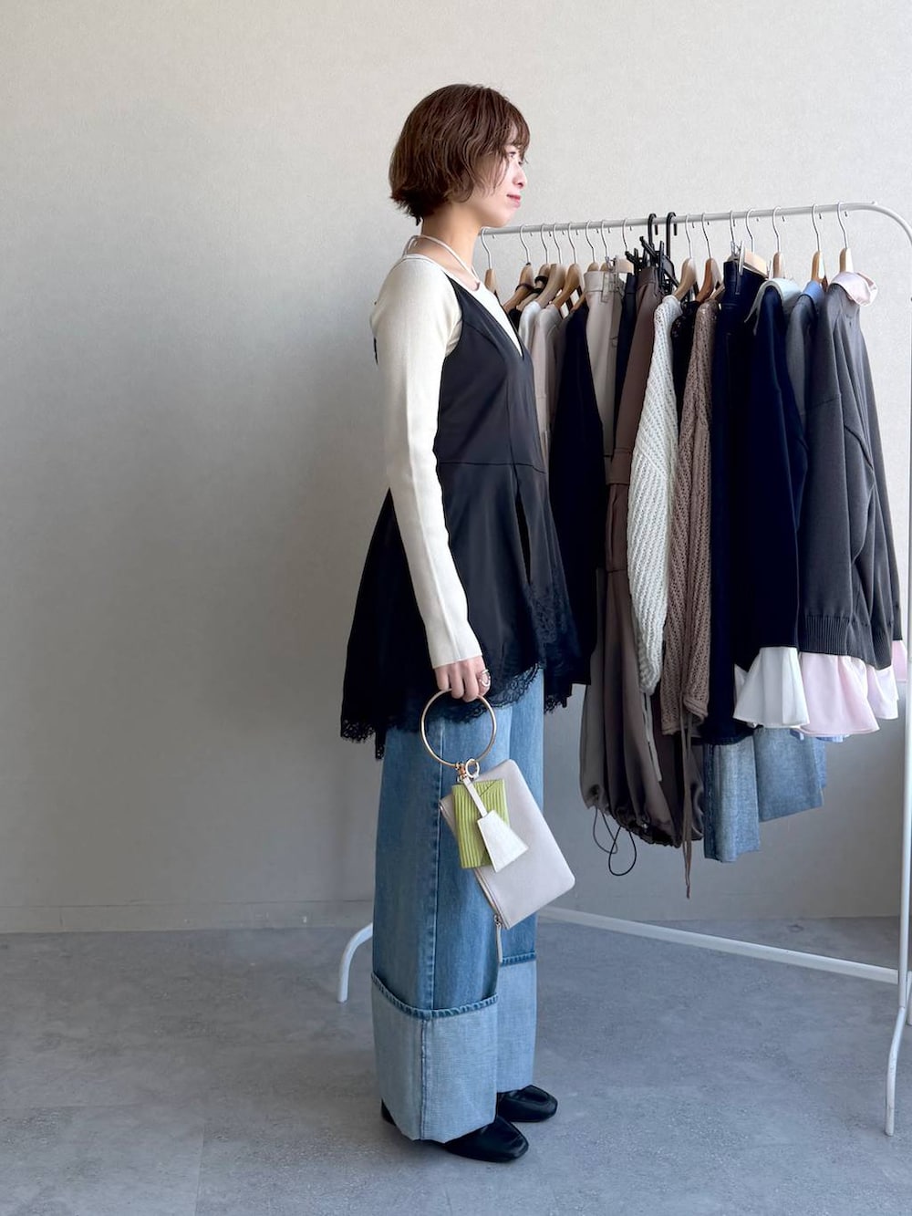 ブラック系のローファー、グレー系のショルダーバッグ、ホワイト系のニット/セーターを着用したレディースの春コーディネートの2枚目の写真