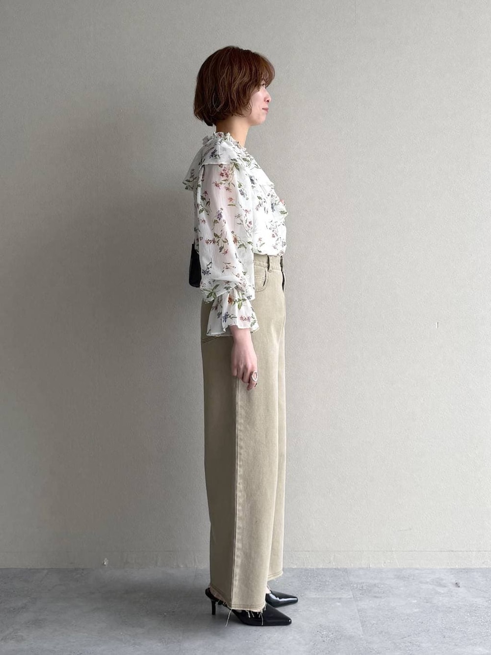 ブラック系のサンダル、ホワイト系のシャツ/ブラウス、ブラック系のショルダーバッグを着用したレディースの春コーディネートの2枚目の写真