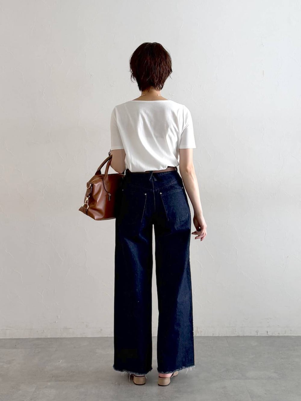 ベージュ系のサンダル、ホワイト系のTシャツ/カットソー、ブルー系のデニムパンツを着用したレディースの夏コーディネートの3枚目の写真