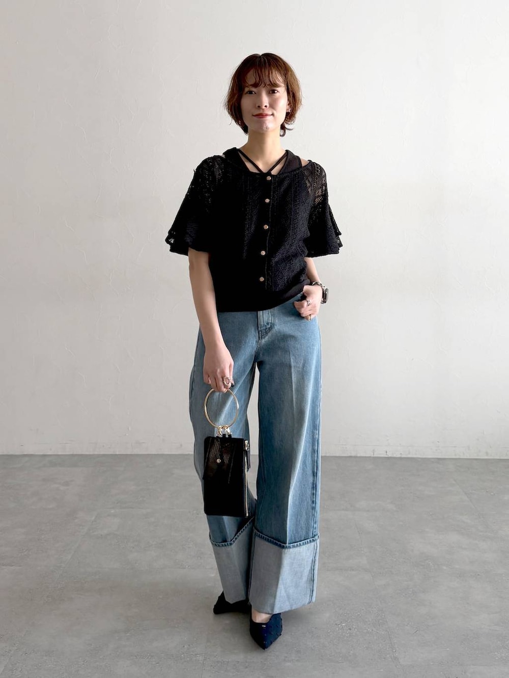 ブルー系のパンプス、ブラック系のショルダーバッグ、ブラック系のカーディガン/ボレロを着用したレディースの冬コーディネートの5枚目の写真