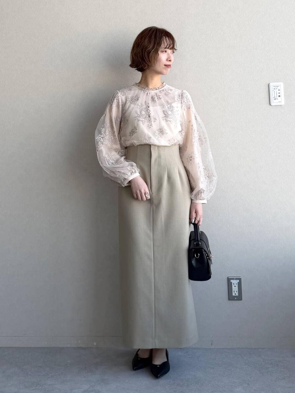 ブラック系のショルダーバッグ、ベージュ系のテーラードジャケット、ベージュ系のスカートを着用したレディースの冬コーディネートの4枚目の写真