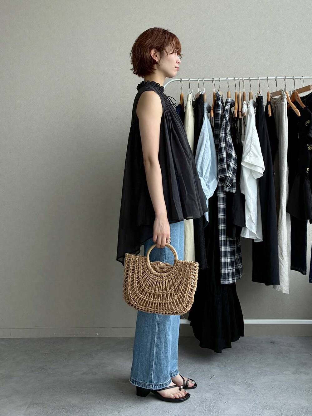 ブラック系のシャツ/ブラウス、ブルー系のデニムパンツ、ベージュ系のかごバッグを着用したレディースの夏コーディネートの2枚目の写真
