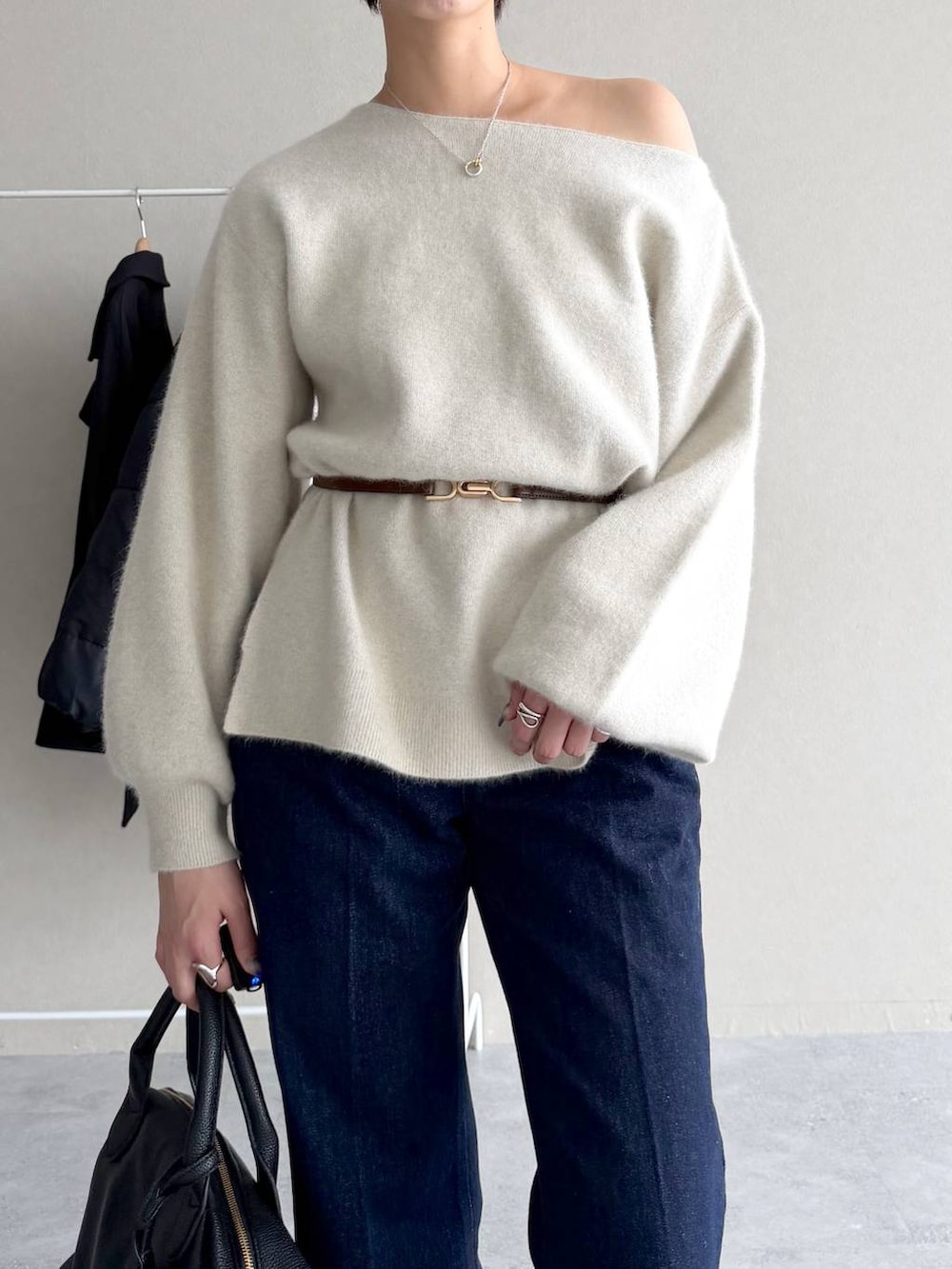 ブルー系のデニムパンツ、ブラック系のボストンバッグ、ホワイト系のナイロンジャケットを着用したレディースの秋コーディネートの8枚目の写真