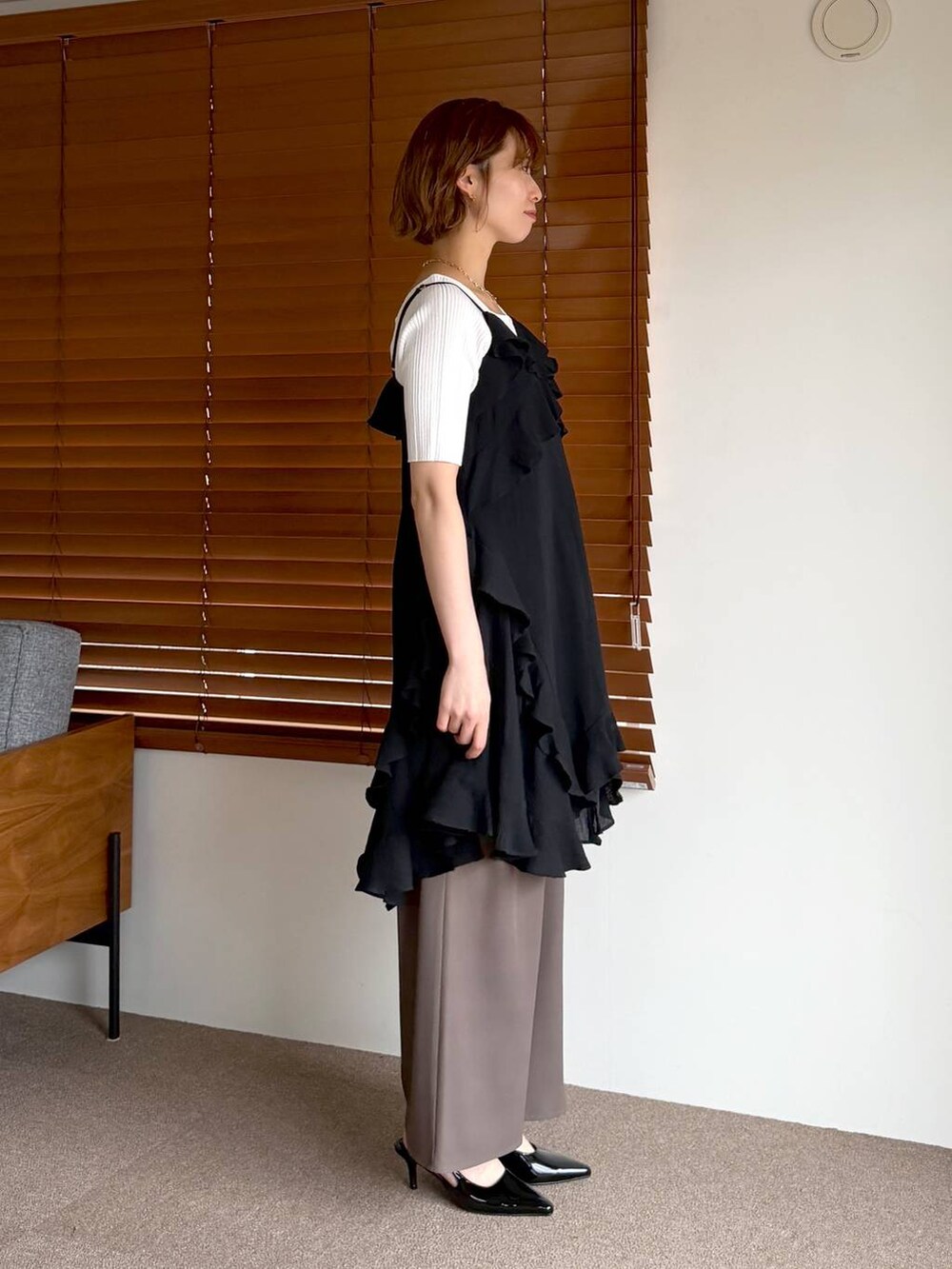 ブラック系のサンダル、ブラック系のショルダーバッグ、ブラック系のチュニックを着用したレディースの春コーディネートの2枚目の写真