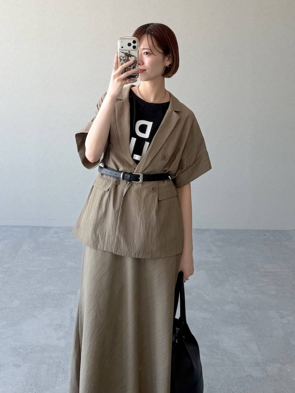 ブラック系のサンダル、ブラック系のTシャツ/カットソー、ブラウン系のスカートを着用したレディースの春コーディネートの6枚目の写真