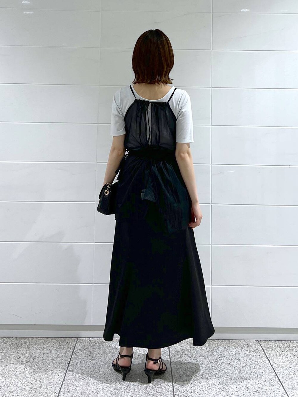 ブラック系のスカート、ブラック系のキャミソール、ブラック系のショルダーバッグを着用したレディースの夏コーディネートの3枚目の写真