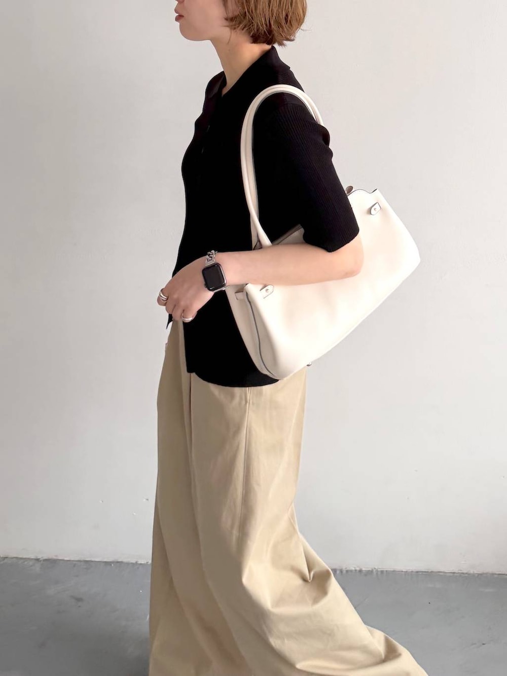 ブラック系のカーディガン/ボレロ、ベージュ系のチノパンツ、ホワイト系のショルダーバッグを着用したレディースの春コーディネートの5枚目の写真