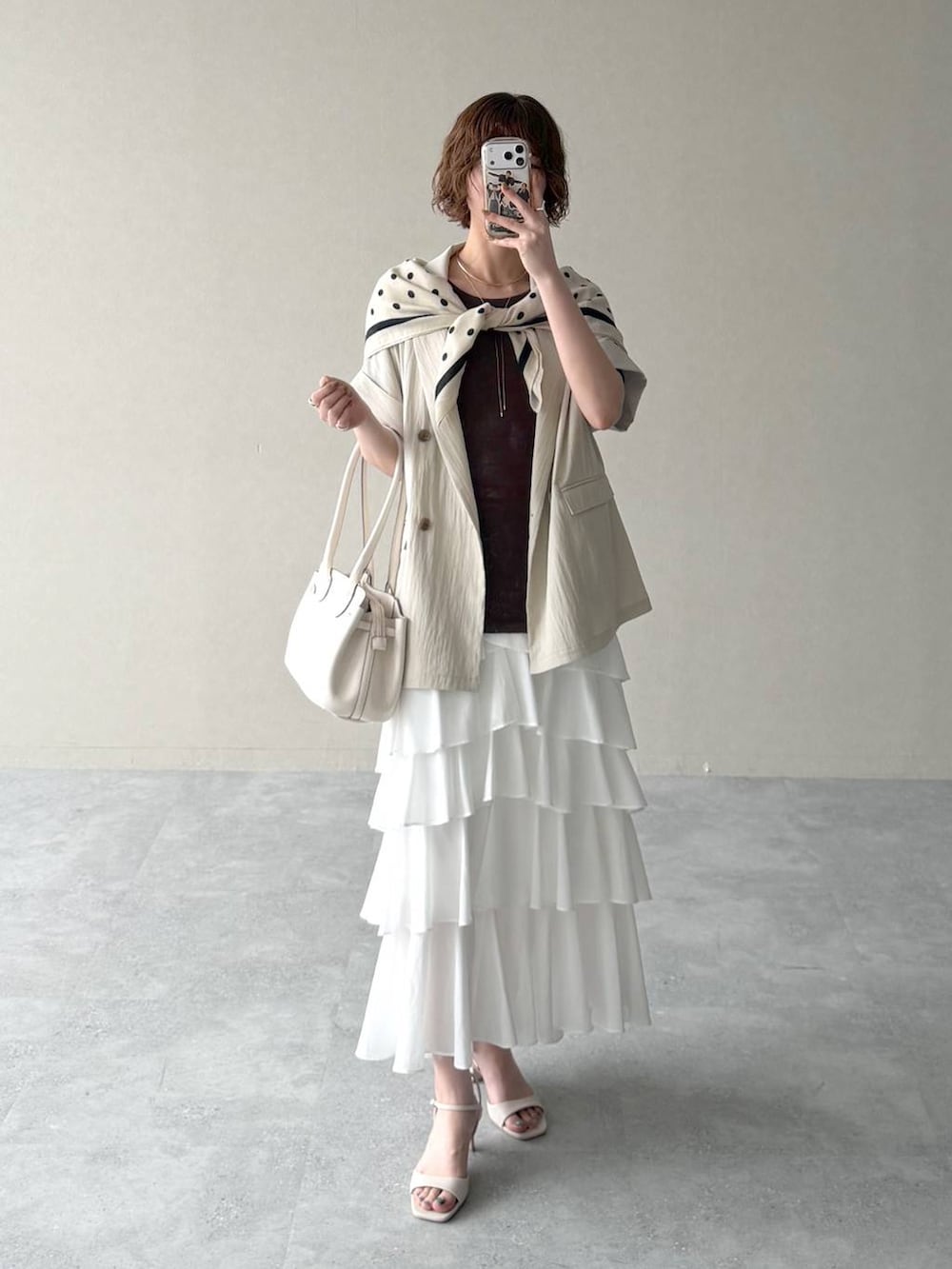 ホワイト系のサンダル、ブラウン系のTシャツ/カットソー、ホワイト系のスカートを着用したレディースの春コーディネートの5枚目の写真