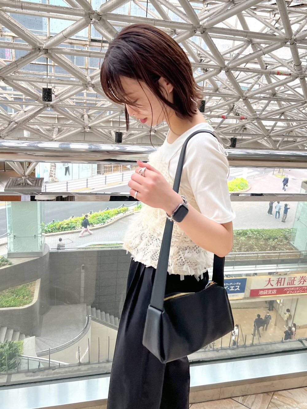 ブラック系のサンダル、ブラック系のスラックス、ブラック系のショルダーバッグを着用したレディースの春コーディネートの4枚目の写真