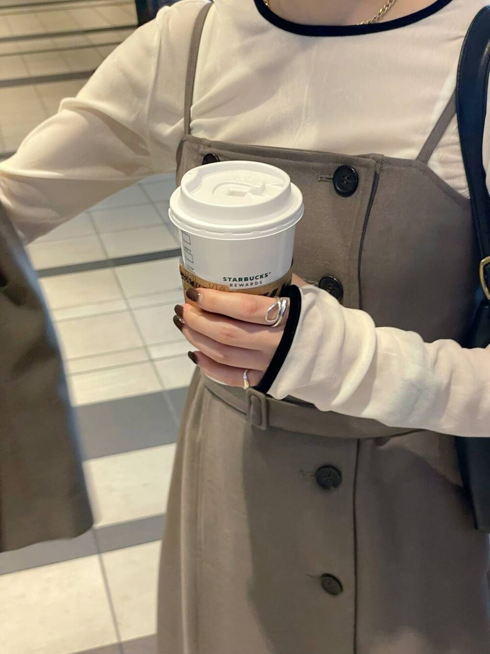 ホワイト系のTシャツ/カットソー、ブラック系のローファー、ベージュ系のワンピースを着用したレディースの秋コーディネートの8枚目の写真