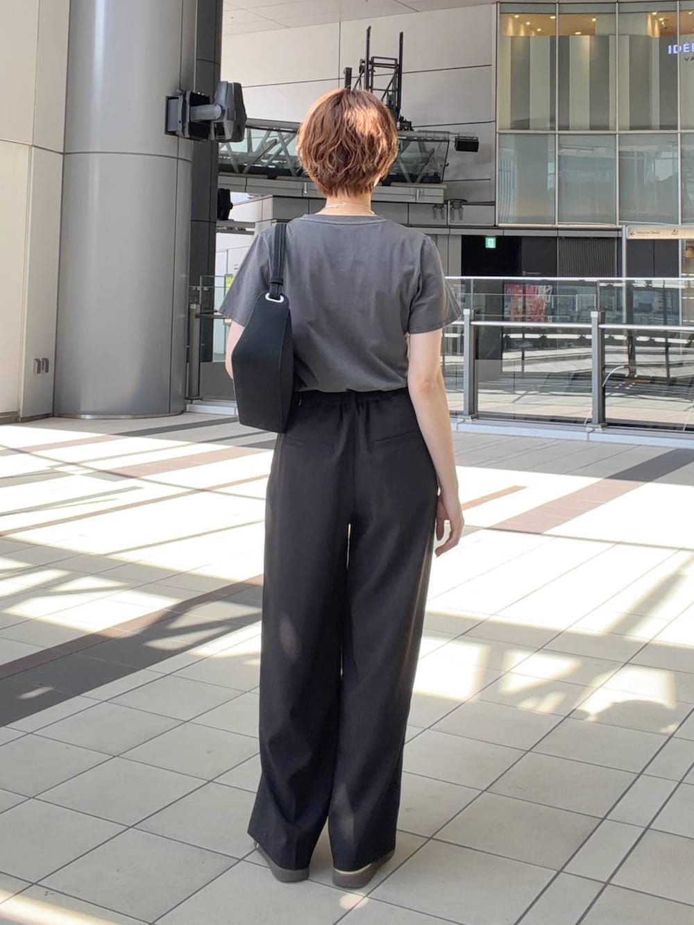 グレー系のTシャツ/カットソー、ブラック系のショルダーバッグ、ブラウン系のサングラスを着用したレディースの夏コーディネートの3枚目の写真