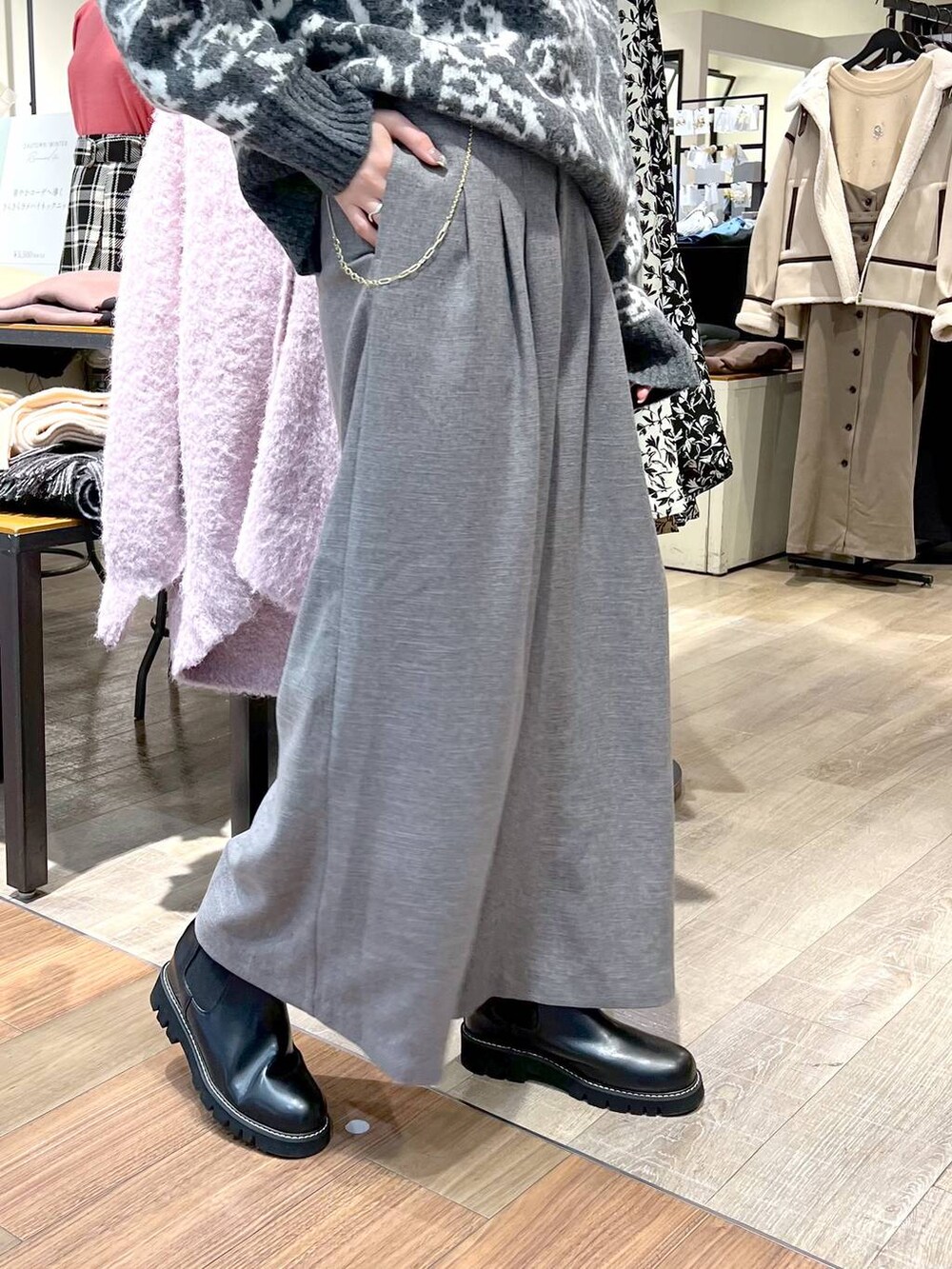 ブラック系のハンドバッグ、ブラック系のブーツ、グレー系のニット/セーターを着用したレディースの冬コーディネートの5枚目の写真