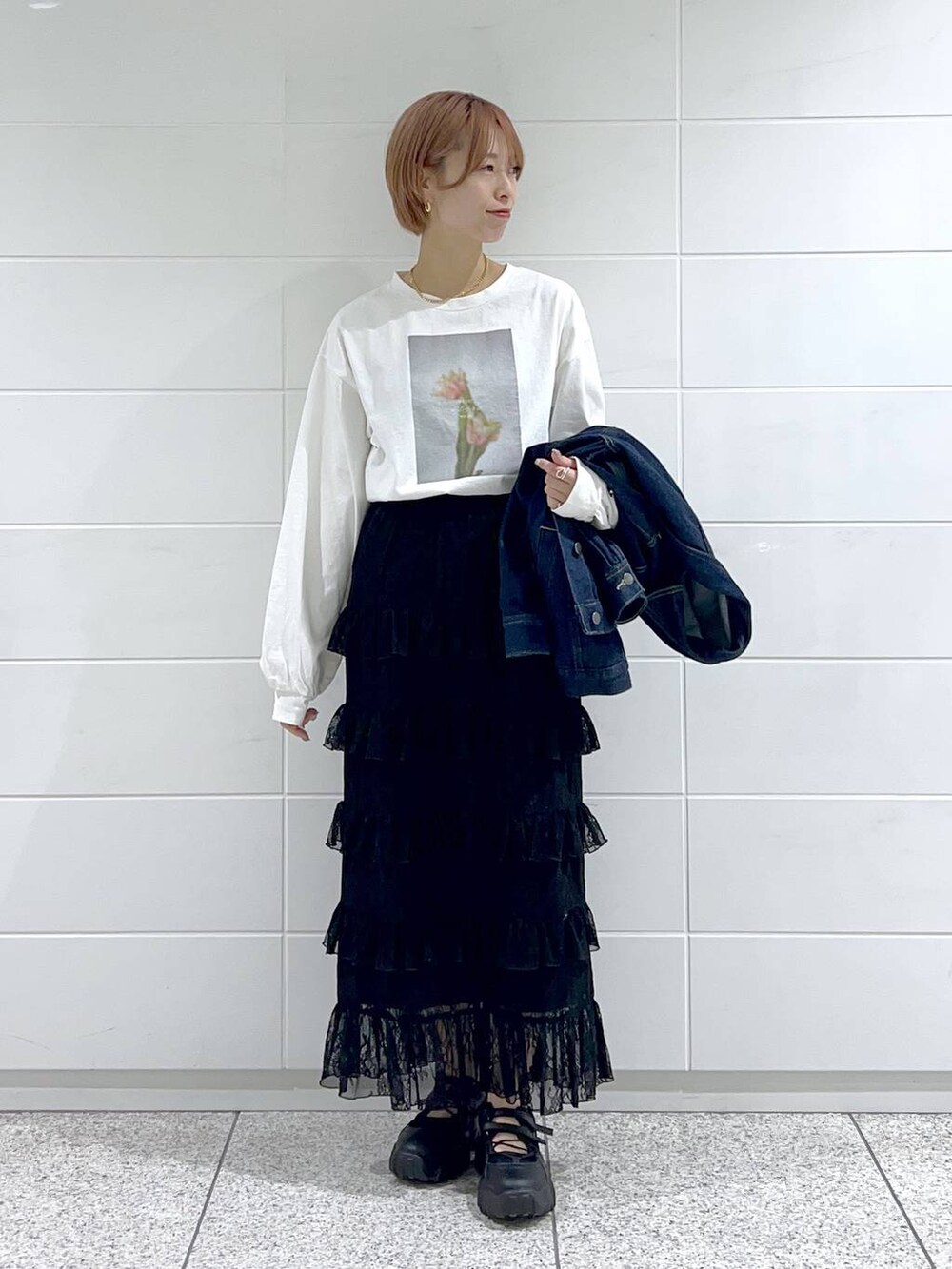 ホワイト系のトートバッグ、ブルー系のデニムジャケット、ブラック系のバレエシューズを着用したレディースの春コーディネートの4枚目の写真