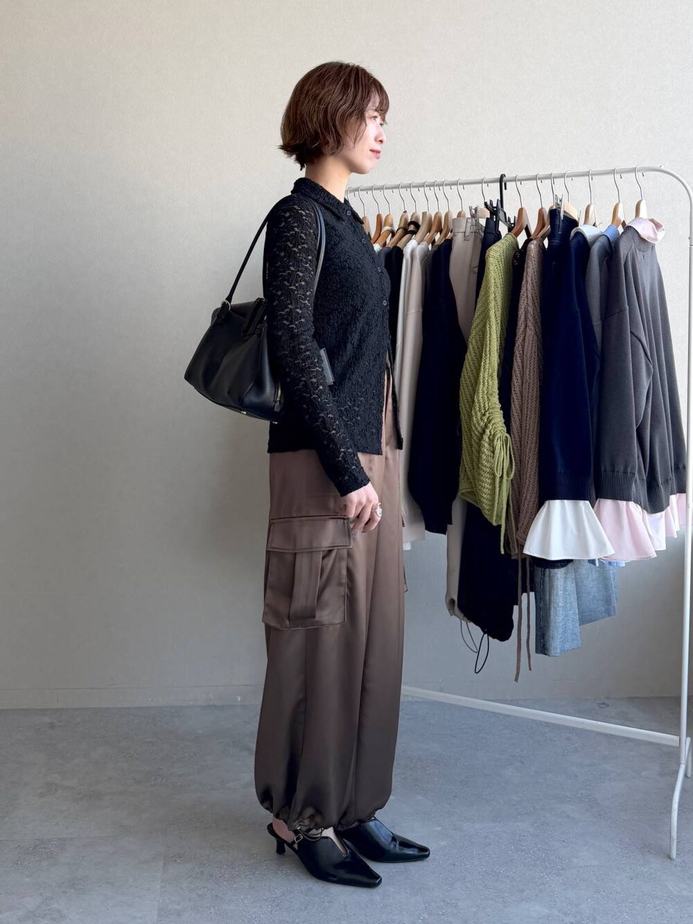 ブラック系のハンドバッグ、ブラック系のサンダル、ブラウン系のその他パンツを着用したレディースの冬コーディネートの2枚目の写真