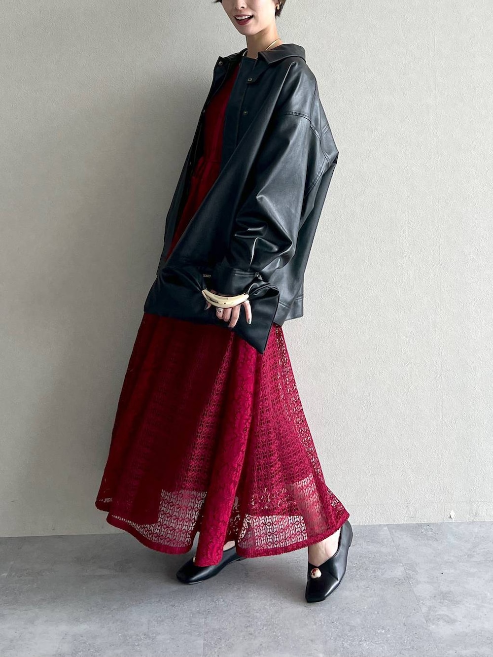 ブラック系のブルゾン、ブラック系のハンドバッグ、レッド系のワンピースを着用したレディースの秋コーディネートの4枚目の写真