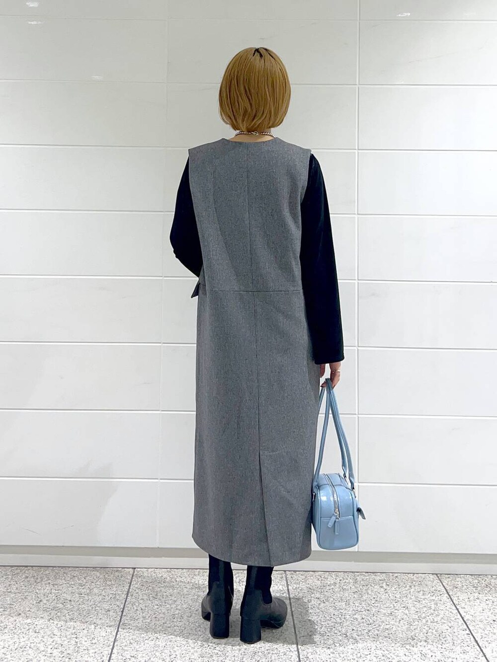 ブラック系のブルゾン、ブラック系のブーツ、グレー系のジャンパースカートを着用したレディースの秋コーディネートの6枚目の写真