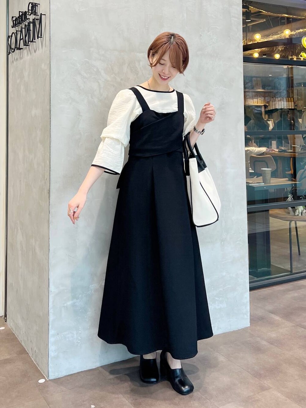 ブラック系のトートバッグ、ホワイト系のシャツ/ブラウス、ブラック系のパンプスを着用したレディースの春コーディネートの7枚目の写真